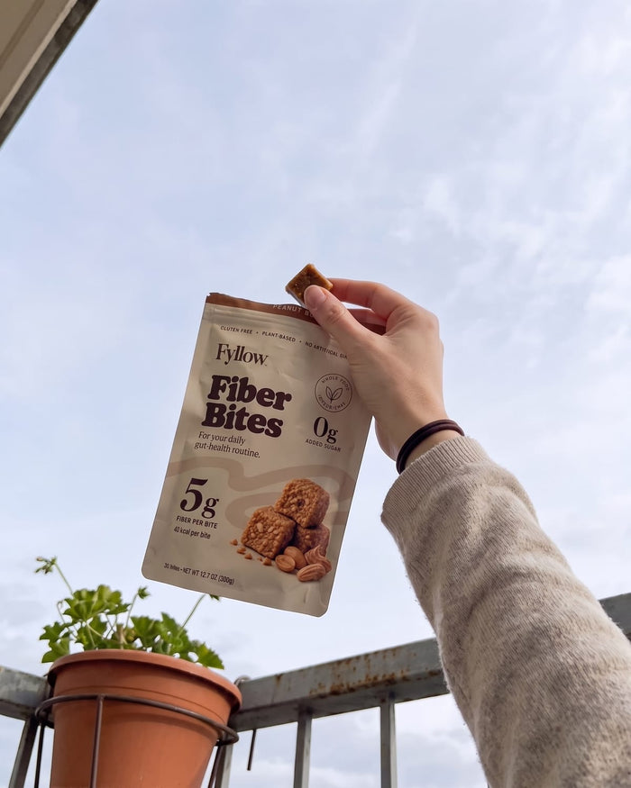 Peanut Butter pouch held up against the sky on a balcony