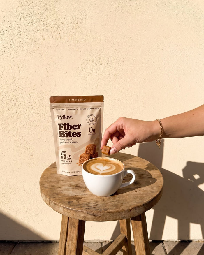 Peanut Butter pouch next to a cappuccino on a wooden stool