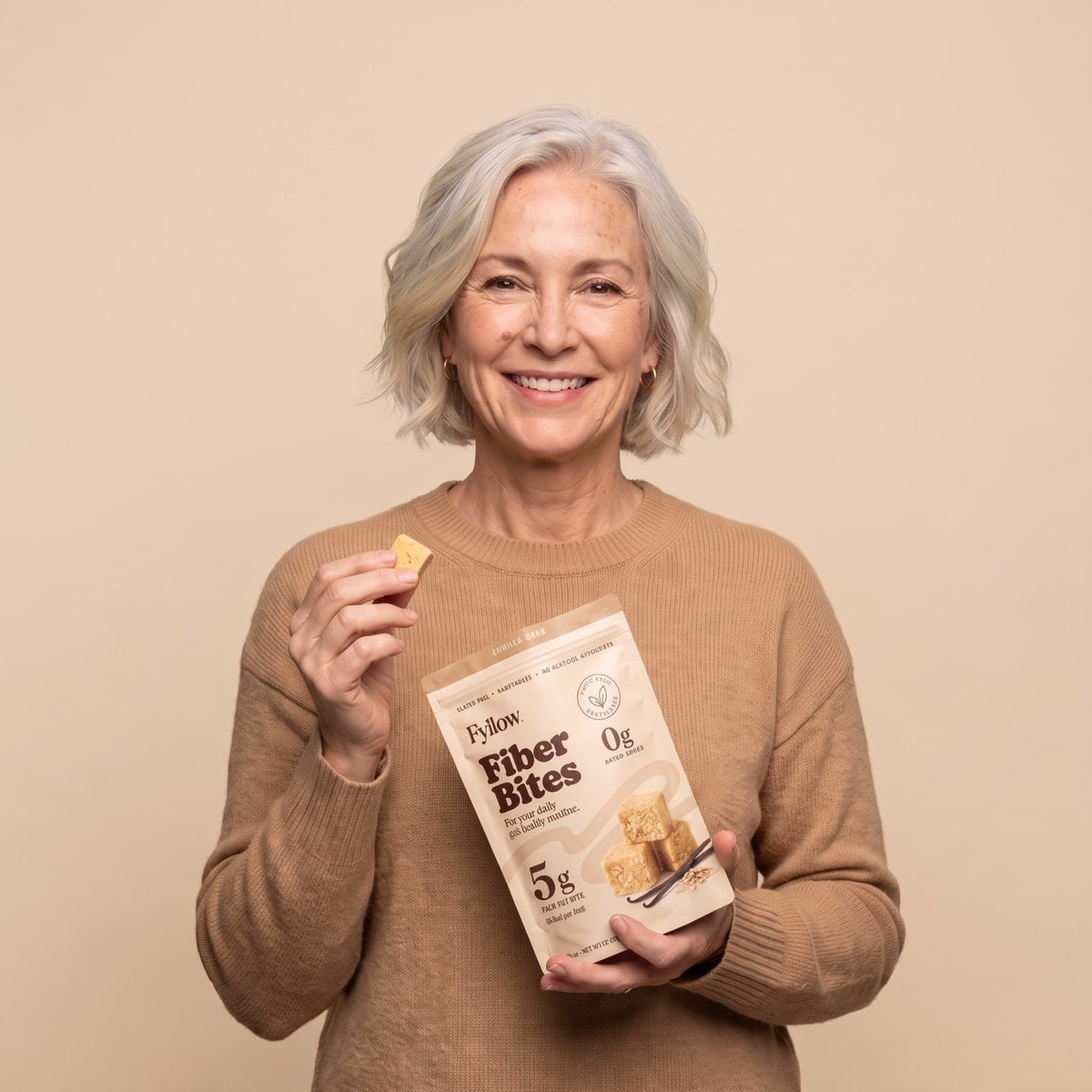Woman in her fifties holding a Vanilla Bean Fiber Bites pouch