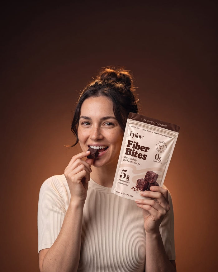 Woman eating a Dark Chocolate Brownie Fiber Bite